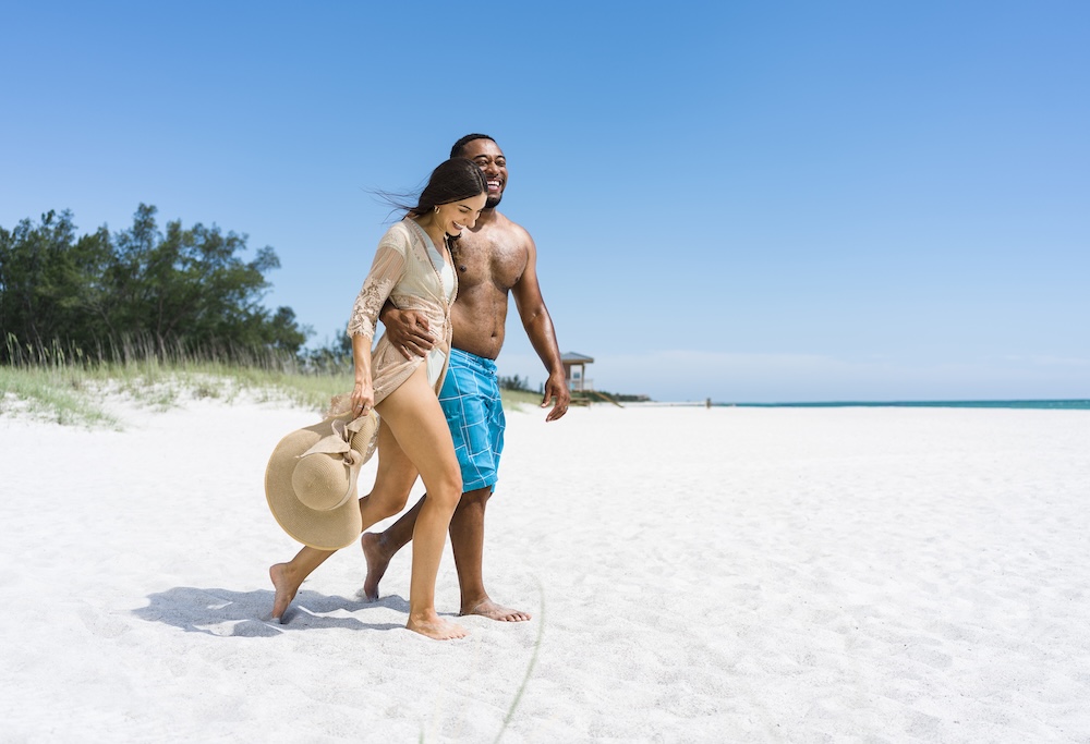 a man and woman walking on a beach