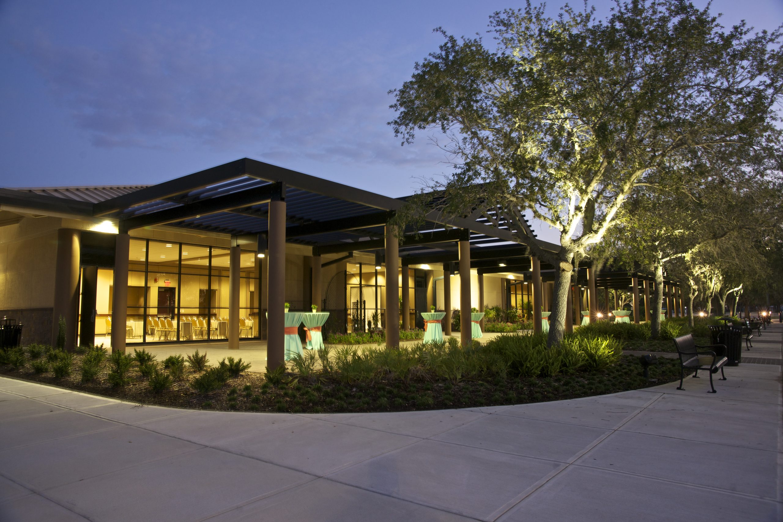 Neatly decorated high top tables are scattered under a patio cover just outside of one of the meeting rooms available in the Bradenton Area Convention Center in Florida's Gulf Coast, creating space for learning and networking.