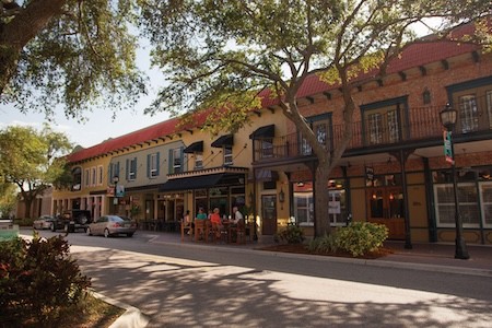 Old Main Street Bradenton with an oak tree canopy and vintage looking brick buildings